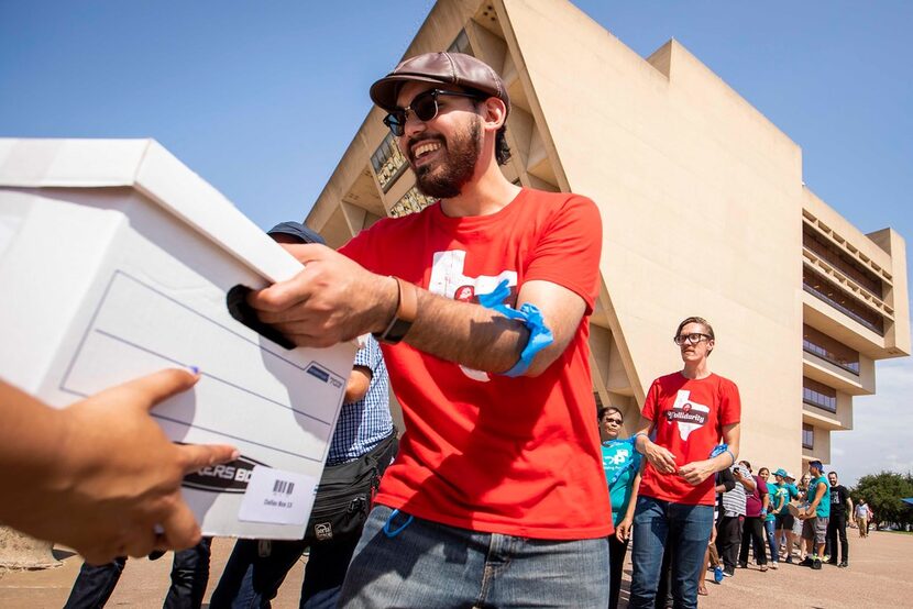 Michael Gonzalez of the Democratic Socialists of America helps unload a truckload of boxes...