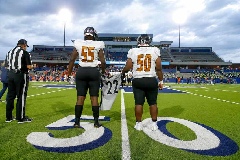 West Mesquite’s Donovan Hawthorne (50) and Trey Mitchell (55) hold a number 22 jersey in...