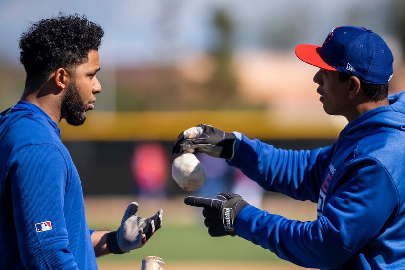 Texas Rangers hitting coach Luis Ortiz works shortstop Elvis Andrus during a spring training...