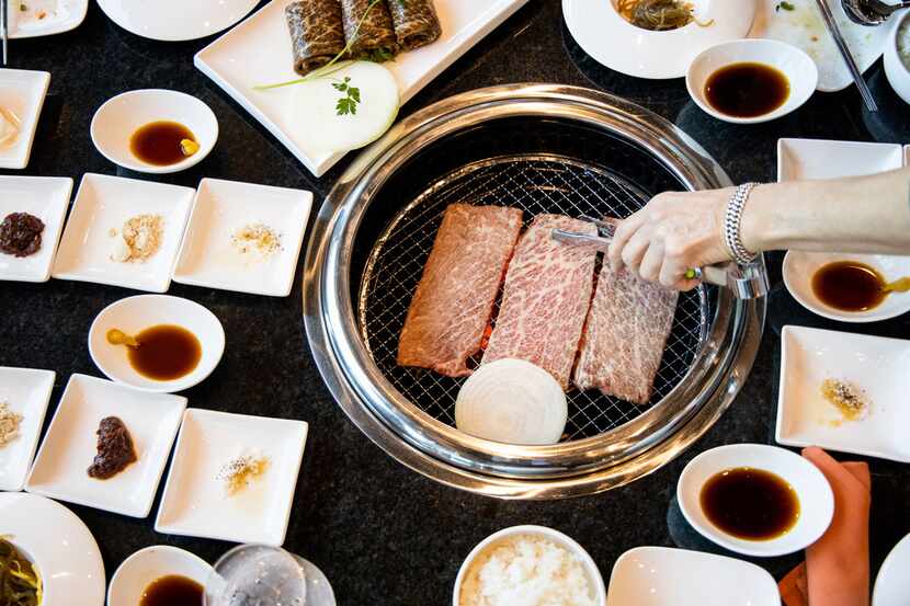 Sammantha Kang adjusts beef short ribs at K's House, a Korean restaurant in Trinity Groves,...