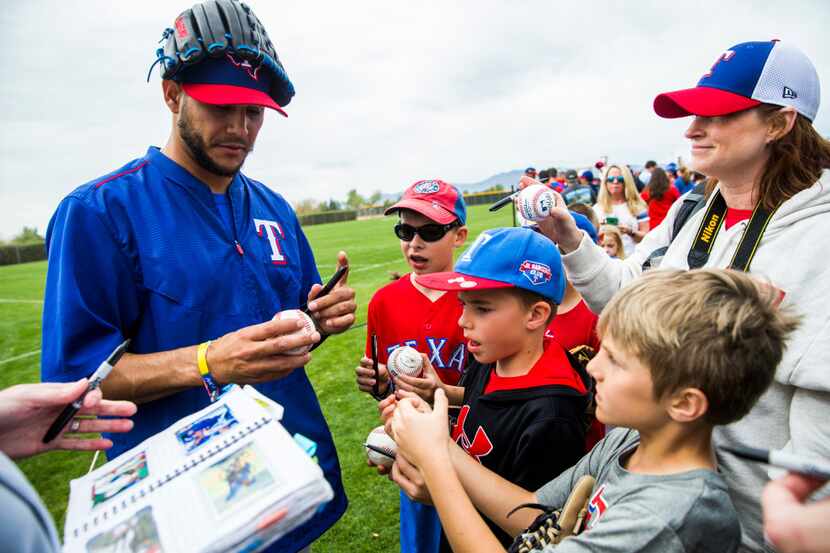 Texas Rangers starting pitcher Martin Perez (33) signs autographs for fans during a spring...
