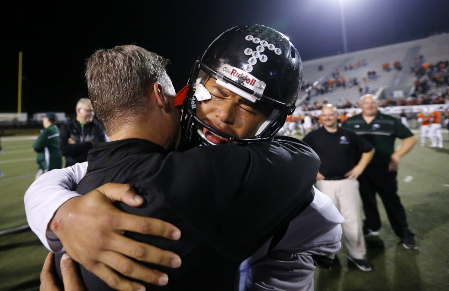 Mansfield Lake Ridge injured quarterback Jett Duffey receives a congratulatory hug from head...