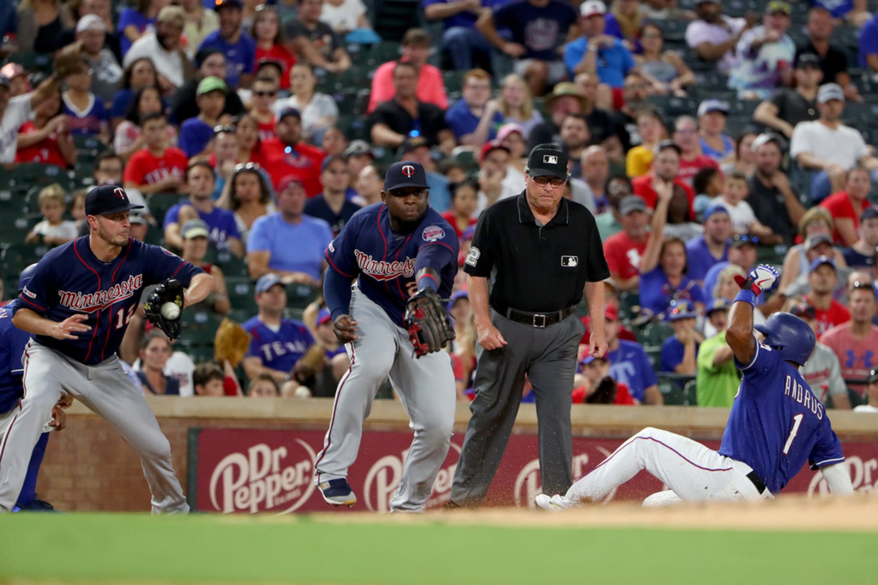 ARLINGTON, TEXAS - AUGUST 16: Elvis Andrus #1 of the Texas Rangers slides into third base...