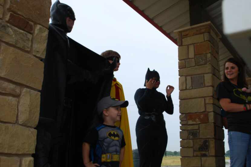 Three-year-old Acen-Jack Miller poses in front of Batman, Robin and Catwoman, who were...