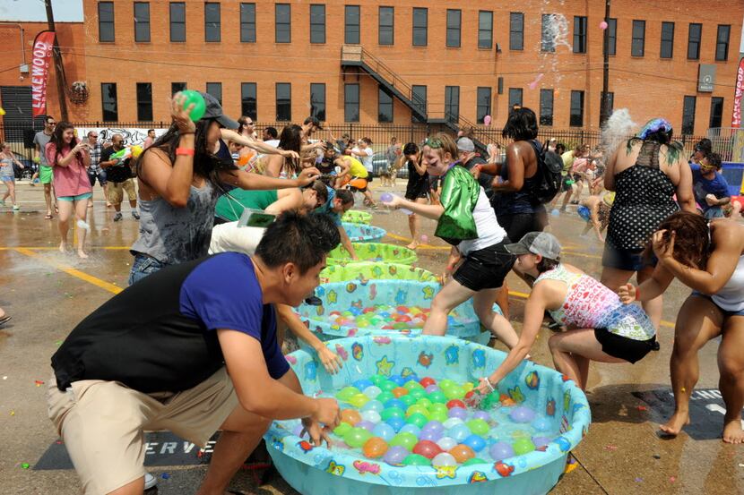 Participants race to grab water balloons at the start of the fight at the Deep Ellum Water...