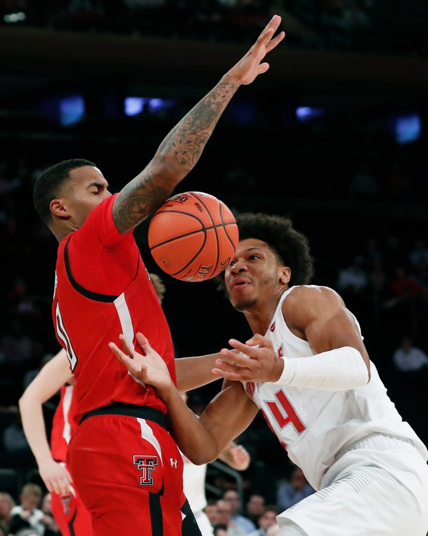 Texas Tech guard Kyler Edwards, left, blocks Louisville forward Dwayne Sutton (24) during...