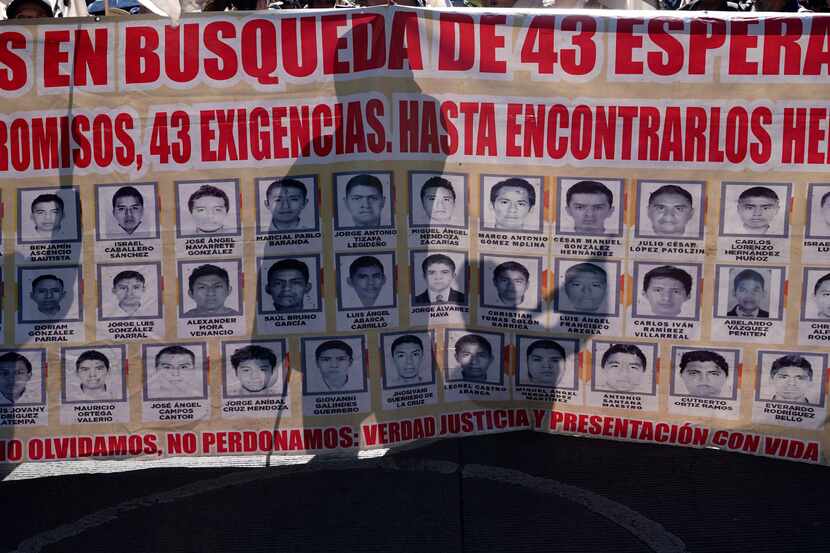 Familiares y simpatizantes con los 43 estudiantes de Ayotzinapa desaparecidos sostienen una...