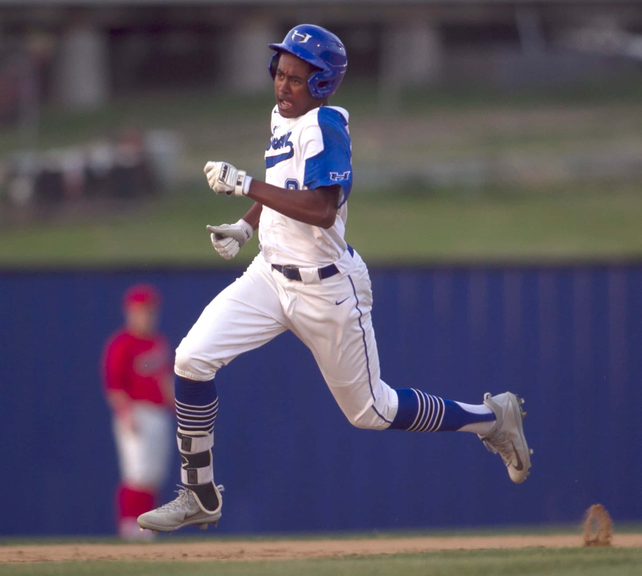 Hebron's Aiden Howard (8) scampers into third base with a triple during the bottom of the...