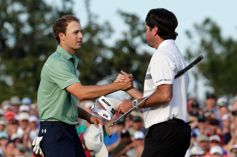 Bubba Watson, right, shakes hands with Jordan Spieth after winning the Masters golf...