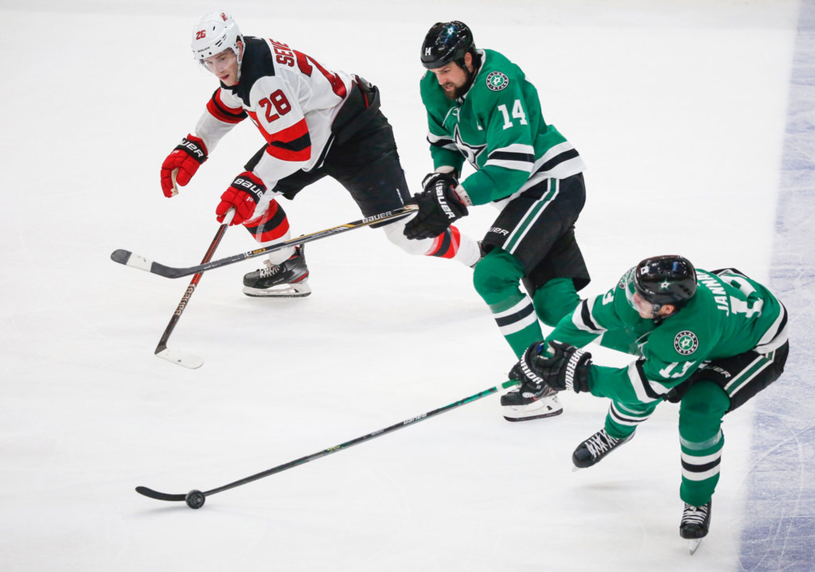 Dallas Stars center Mattias Janmark (13) and left wing Jamie Benn (14) move the puck past...