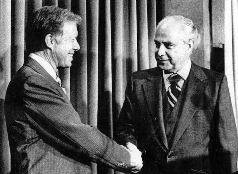 
President Jimmy Carter (left) shakes hands with Ambassador Robert Strauss after Carter...
