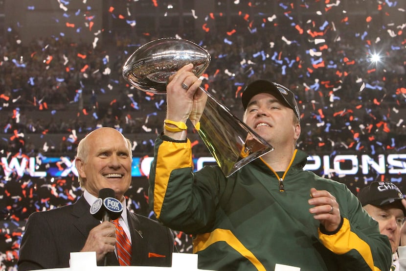 Green Bay Packers head coach Mike McCarthy admired the Lombardi Trophy as Terry Bradshaw...