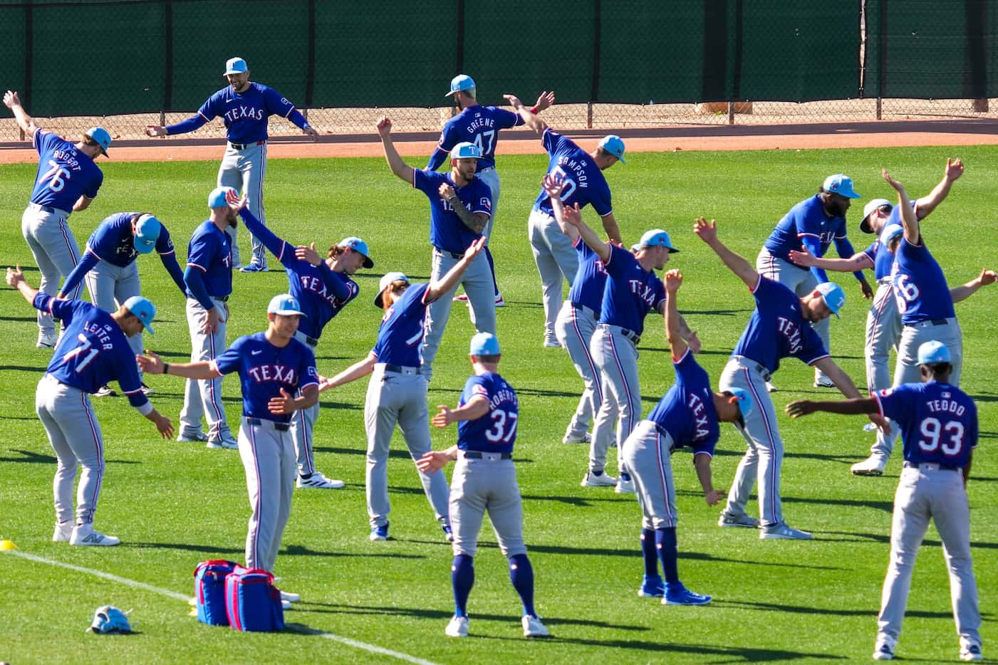 Texas Rangers pitchers stretch during a spring training workout at the team's training...