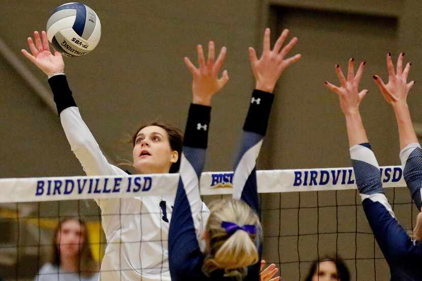 Keller High School outside hitter Melanie McGann (11) gets a hit as V.R. Eaton High School...