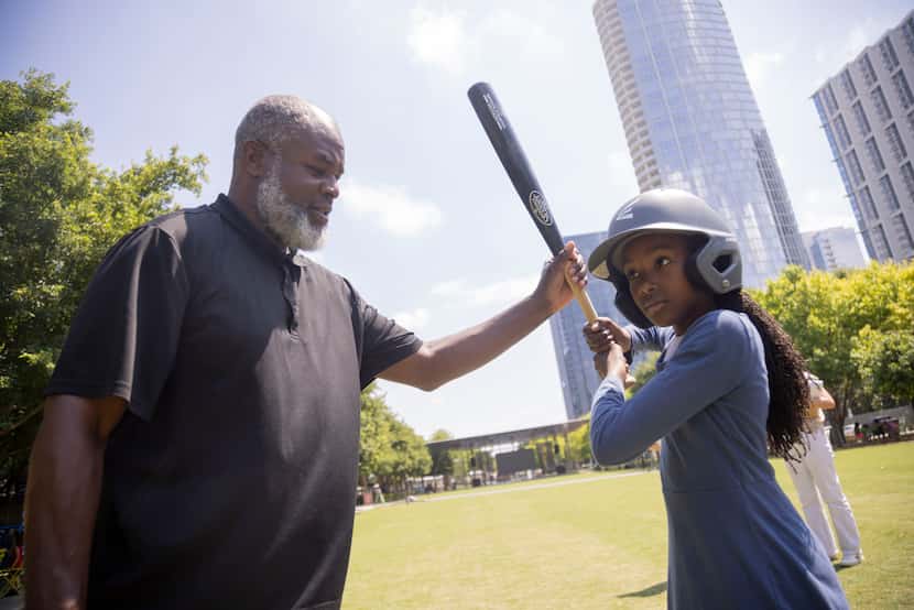 From left, Ali Naeem shows his daughter Lena Naeem, 11, how to hold the baseball bat before...