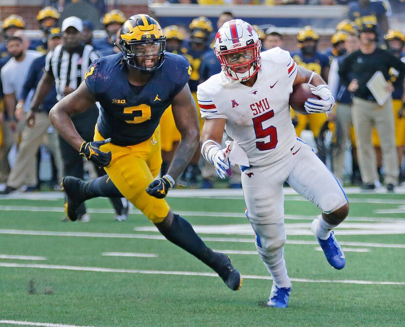 FILE - SMU running back Xavier Jones (5) looks for yardage on a first-half run as Michigan...