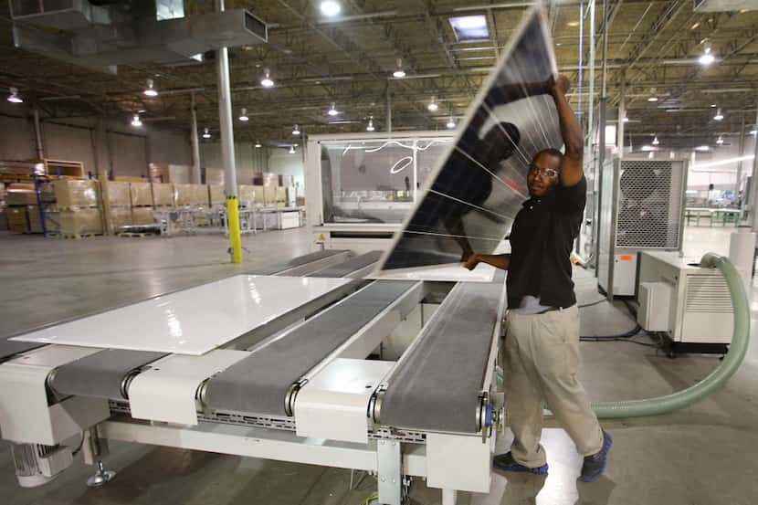 A Worker handles a solar panel at the 1 SolTech Inc. facility in Farmers Branch in September...