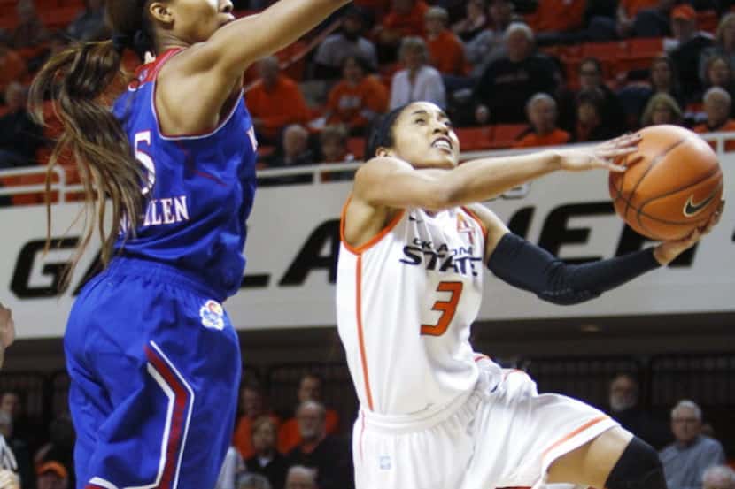 Oklahoma State's Tiffany Bias (1) jumps by Kansas defender Caelynn Manning-Allen (25) as she...