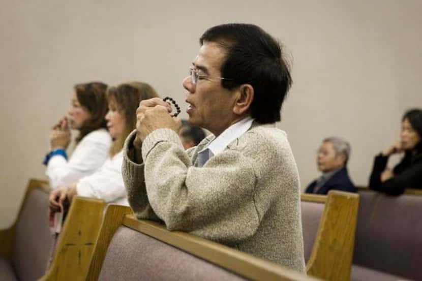 
Parishioner An Nguyen prayed during an evening Mass on Monday at Our Lady of Fatima...