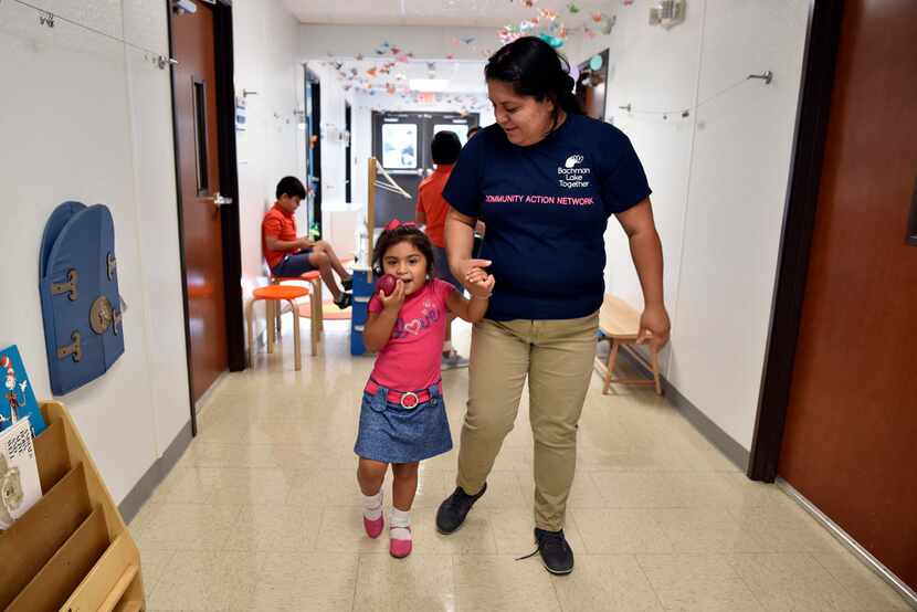 Patricia Vega walks with daughter Elizabeth Diaz before working on activities to help her...