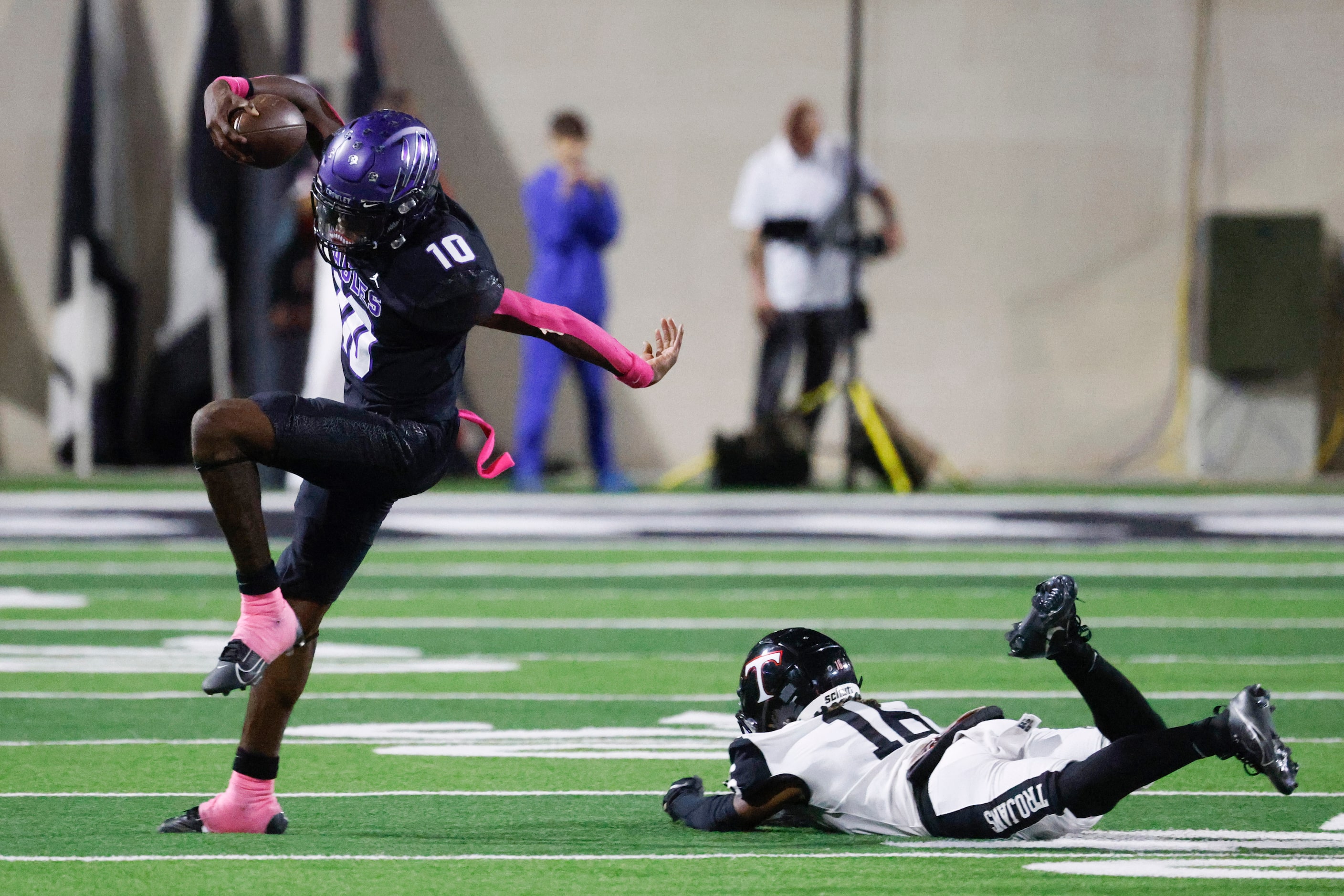 Crowley High’s Caleb Wiliams (10) dodges a tackle by Trinity high’s Lemariea Smith (right)...