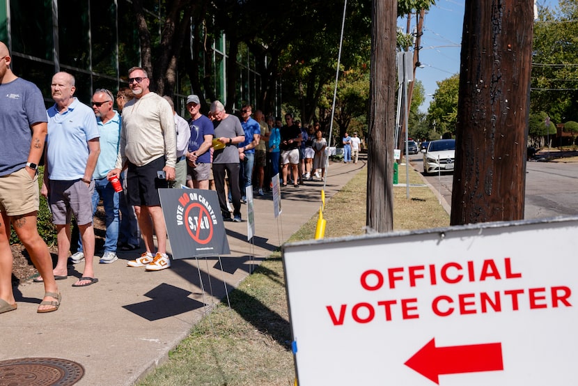 People wait in line to vote outside the Oak Lawn Branch Library polling place on the first...