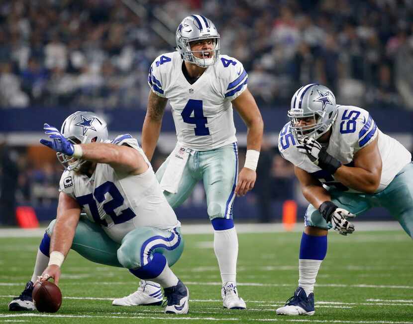 Dallas Cowboys quarterback Dak Prescott (4) yells behind center Travis Frederick (72) and...