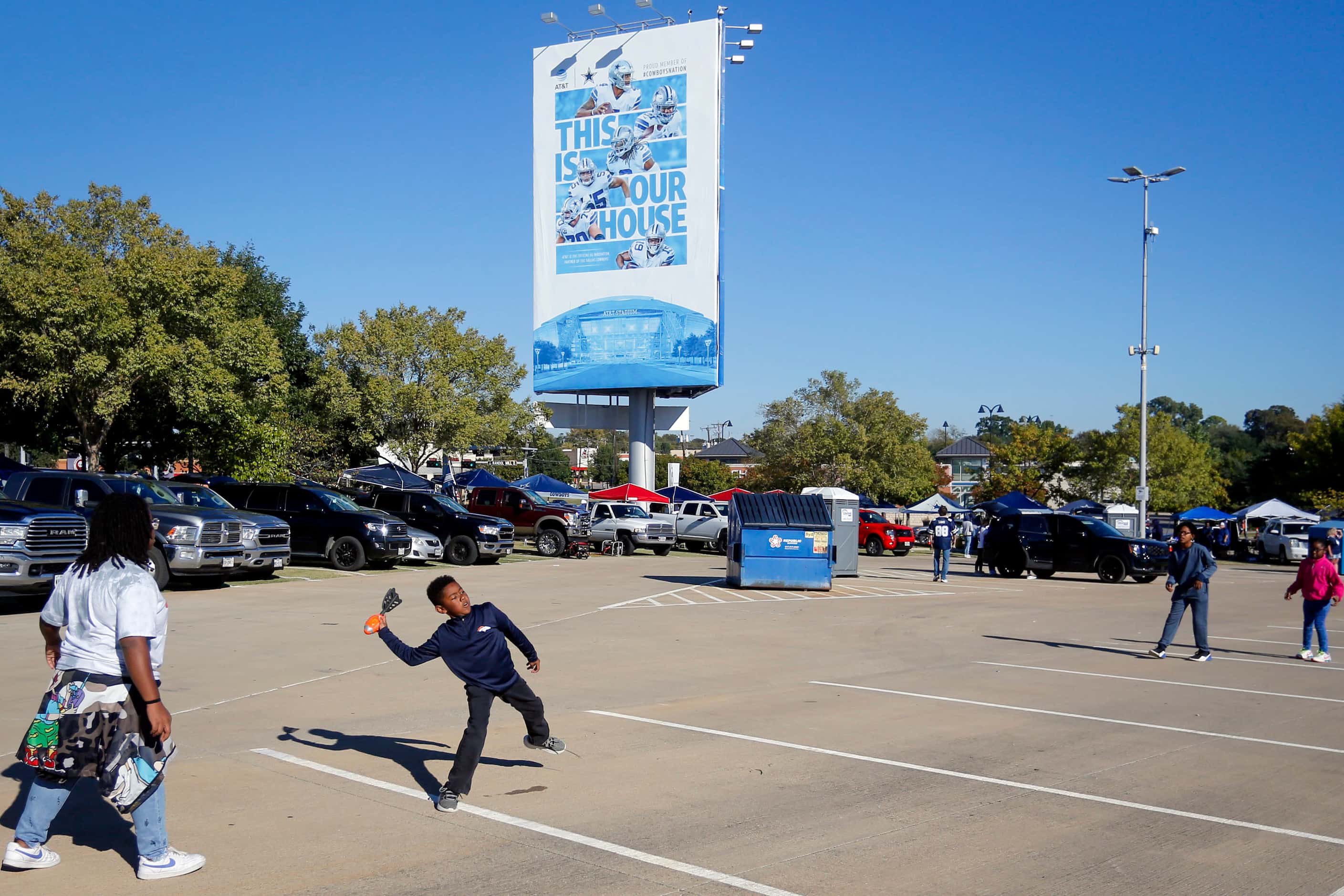 Kids play with a Nerf football on the AT&T Stadium Parking lots before the start of a NFL...