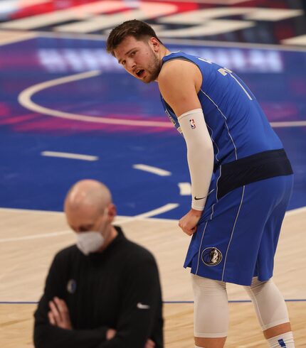 Mavericks guard Luka Doncic (77) talks to head coach Rick Carlisle after picking up his...