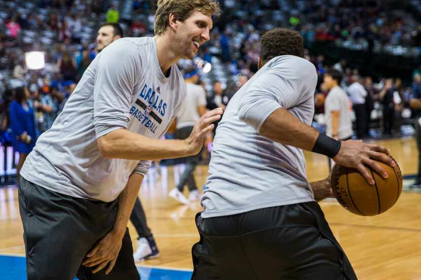 Dallas Mavericks forward Dirk Nowitzki (41) jokes around with guard Justin Anderson (1)...