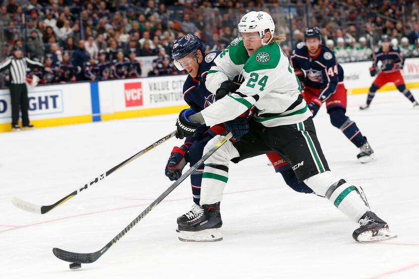 Dallas Stars' Roope Hintz, right, of Finland, tries to shoot as Columbus Blue Jackets' Riley...