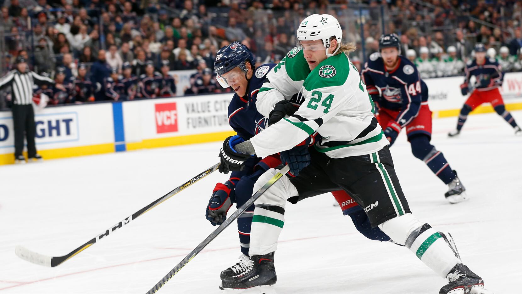Dallas Stars' Roope Hintz, right, of Finland, tries to shoot as Columbus Blue Jackets' Riley...