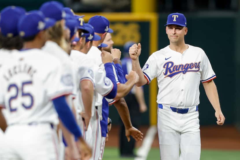 Texas Rangers first baseman Nathaniel Lowe (30) greets teammates before the season opener at...