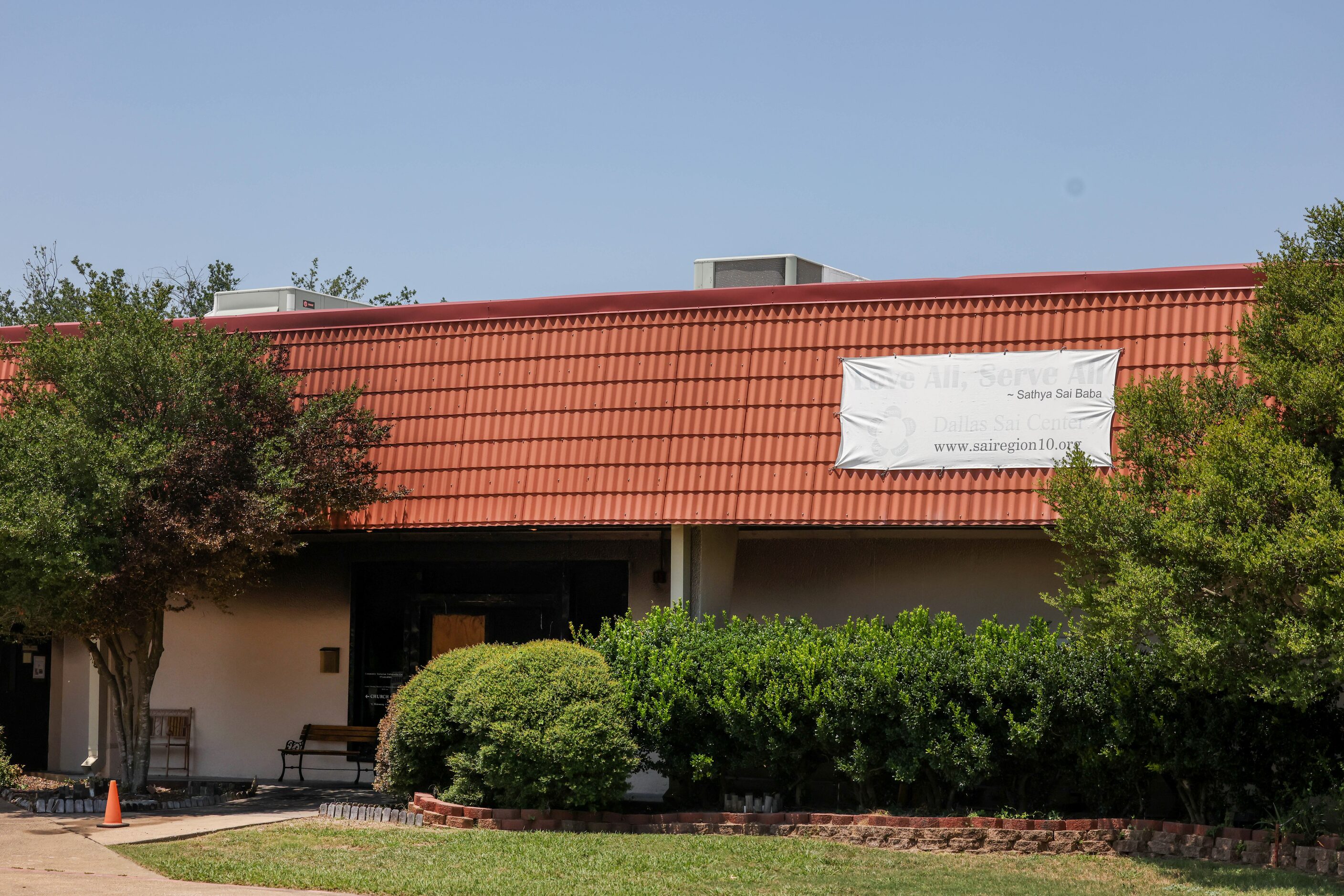 The damaged doorway of Community Unitarian Universalist Church of Plano is covered in shade...