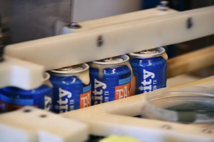 Cans move through the canning line at Audacity Brew House as they produce their "Free...