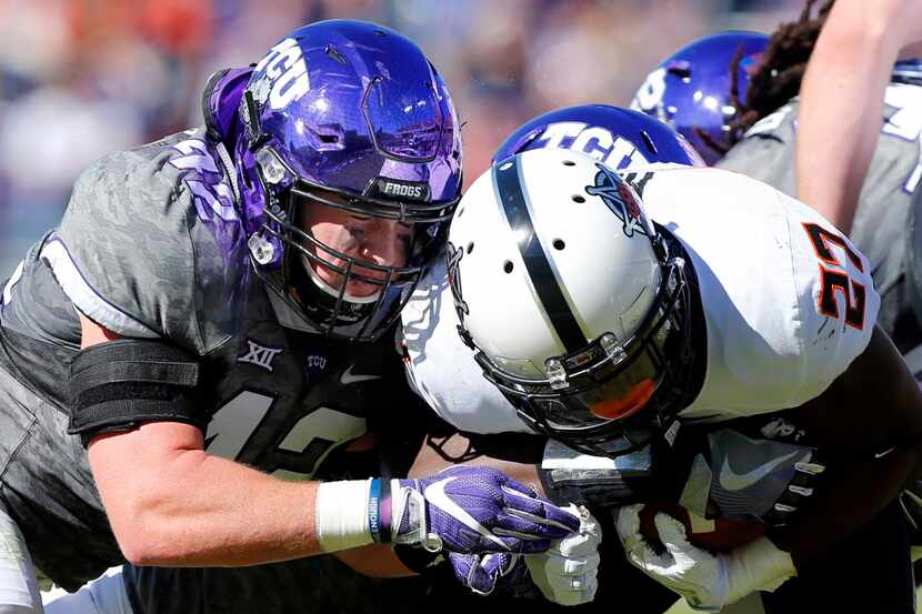 TCU Horned Frogs linebacker Ty Summers (42) puts the hit Oklahoma State Cowboys running back...