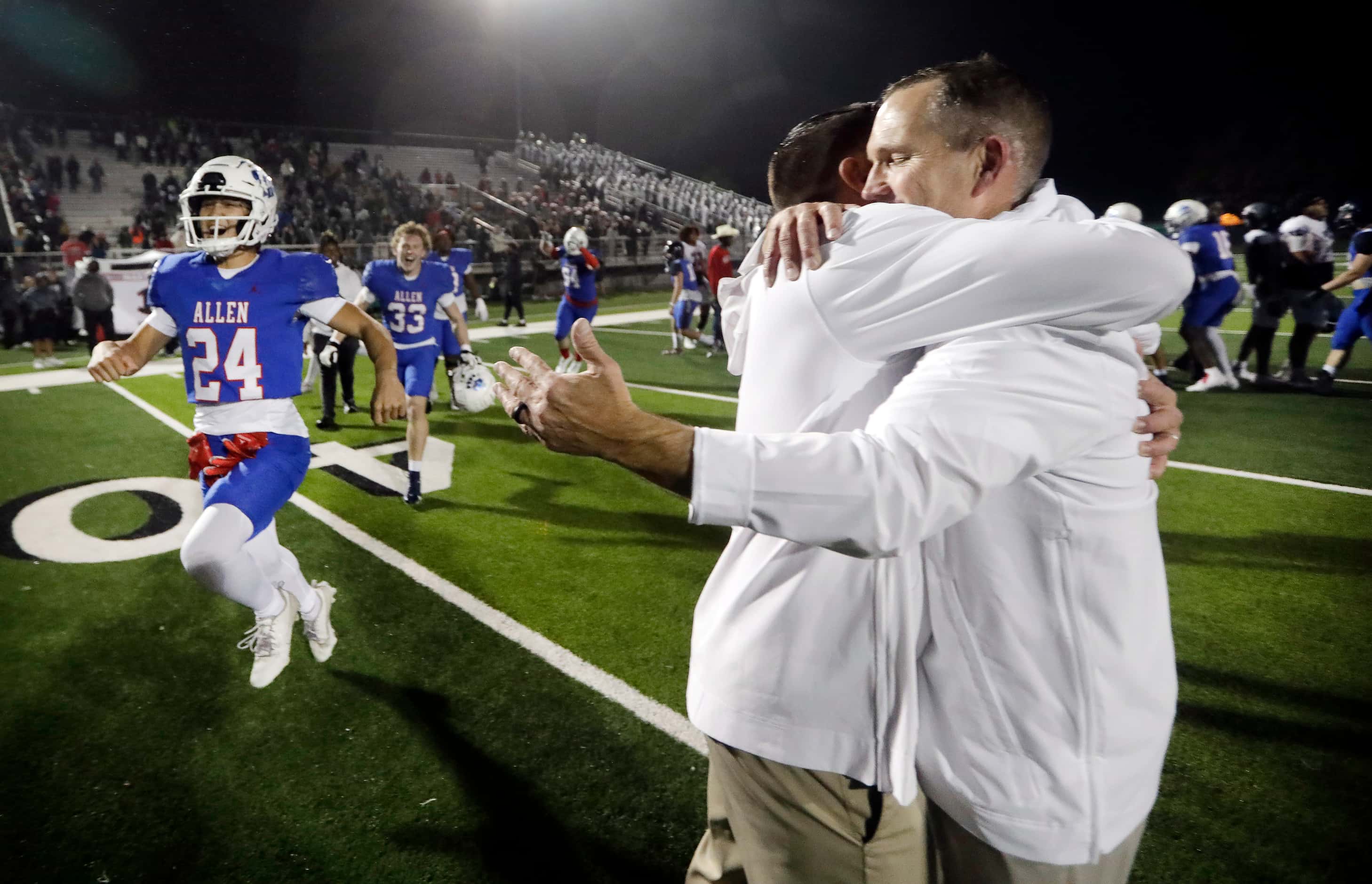 Allen head coach Lee Wigginton (right) receives a hug from one of his coaches as the team...