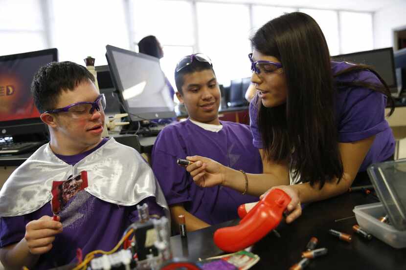 Senior Ivonne Torres, captain of the robotics team, shows special education students Tomas...