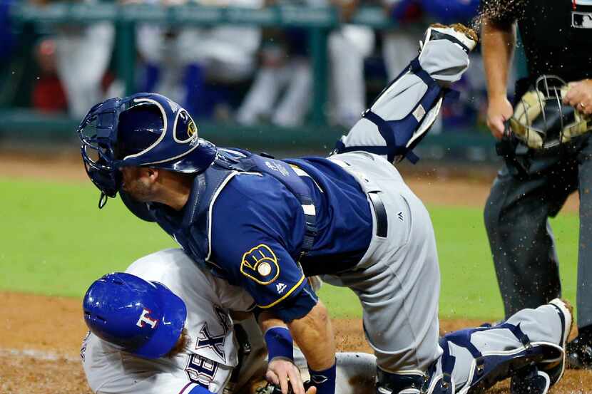 Milwaukee Brewers catcher Manny Pina (9) tags out Texas Rangers Jonathan Lucroy (25) at home...