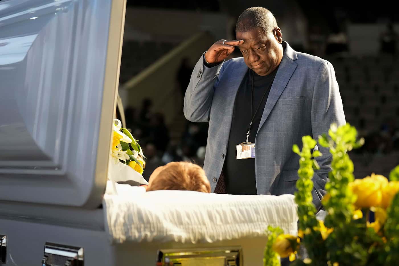 Dallas police Sgt. Kenneth Wilkins salutes as he pays his respects at the casket of former...
