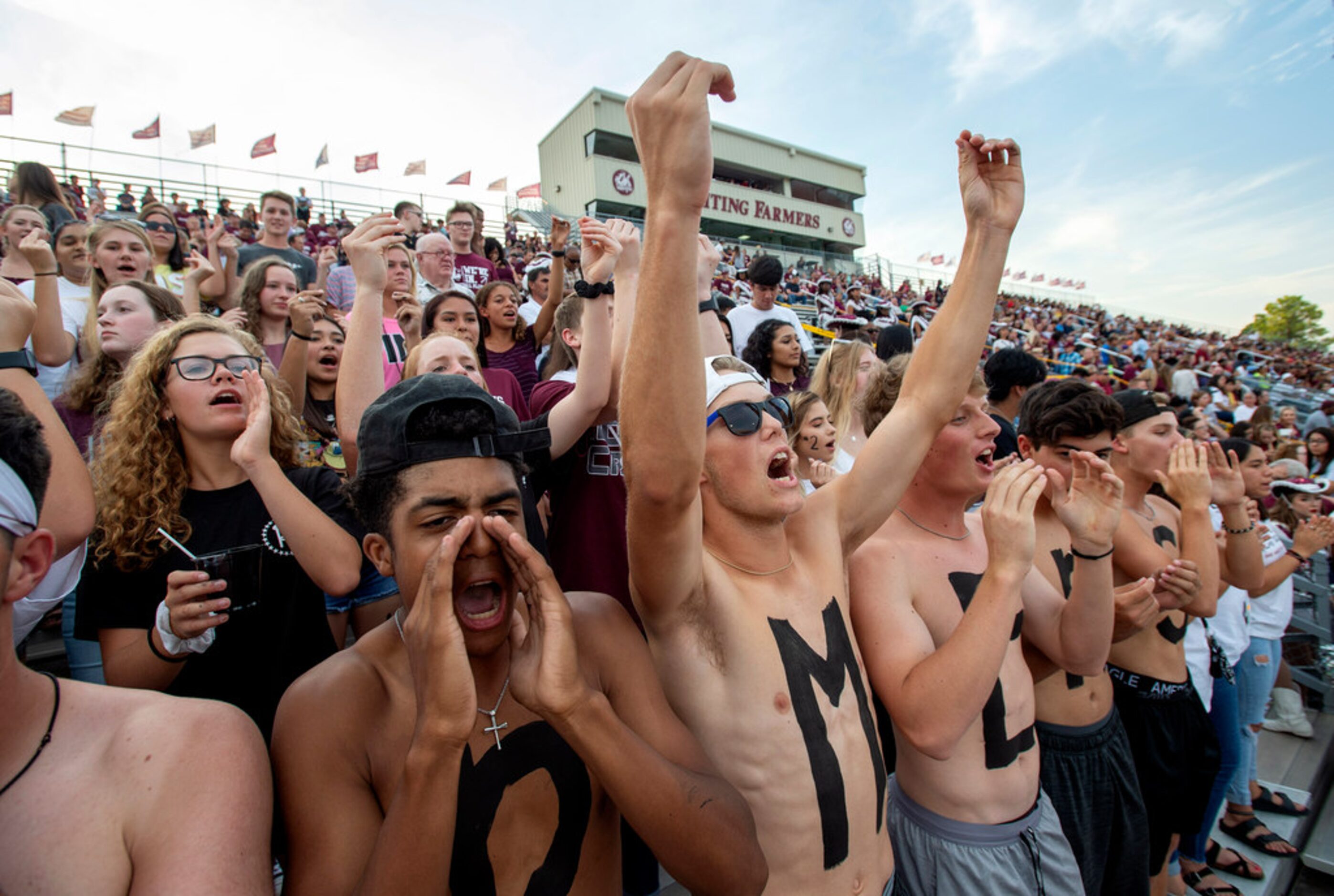 Lewisville seniors Braylun Granderson, Trey West, and Dylan Becker cheer in the students...