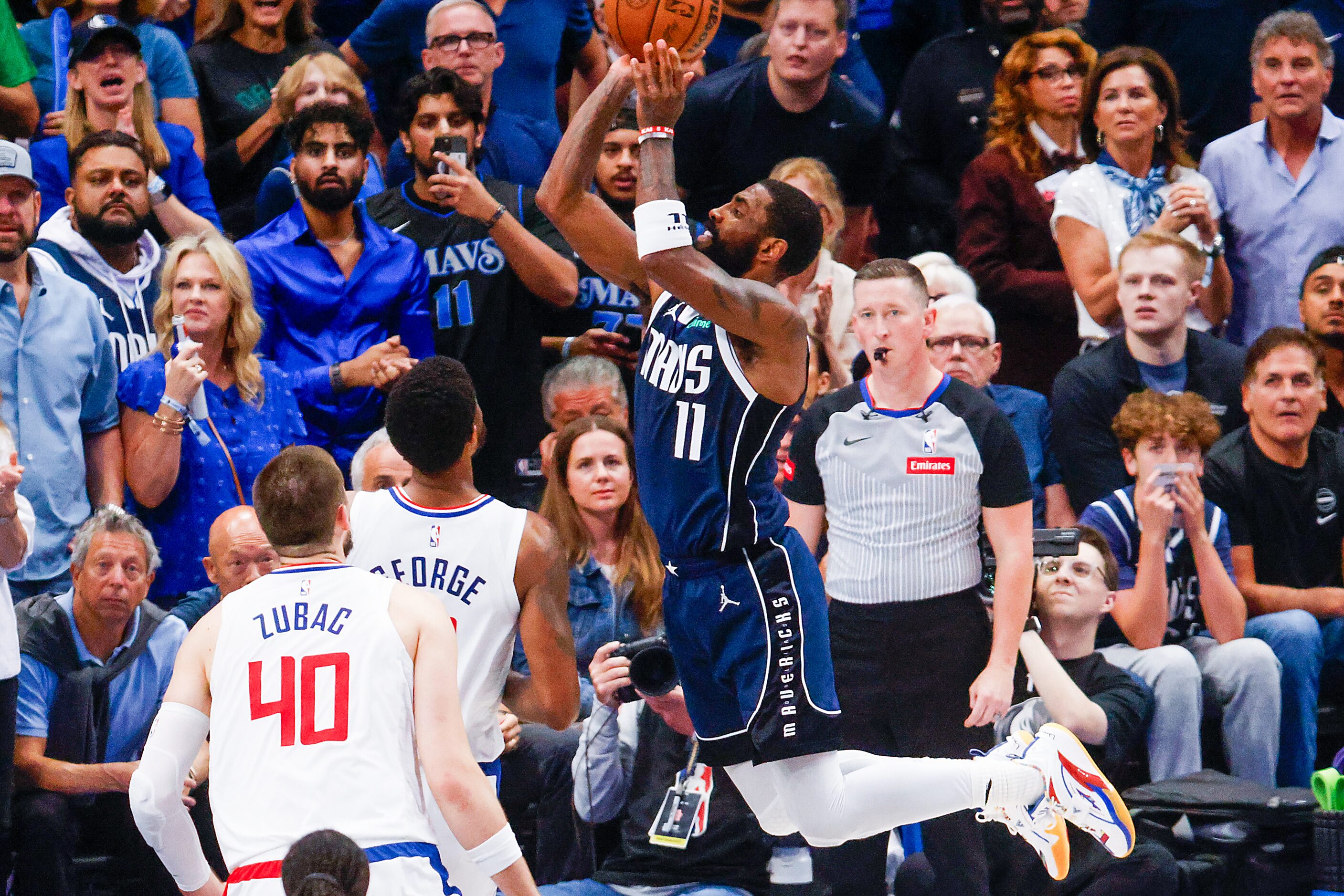 Dallas Mavericks guard Kyrie Irving goes up for a shot over LA Clippers forward Paul George...