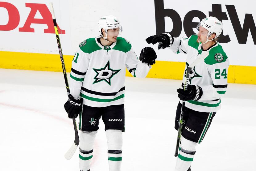 Dallas Stars left wing Jason Robertson (21) is congratulated by teammate Roope Hintz (24)...