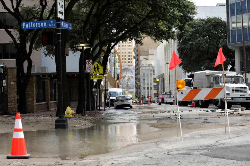 Workers secure an area damaged by a water main break in downtown Dallas in August 2021.