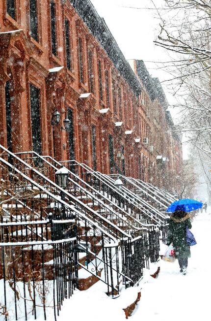 A woman carries an umbrella on a snowy day in Brooklyn. Be careful: One strong gust of...