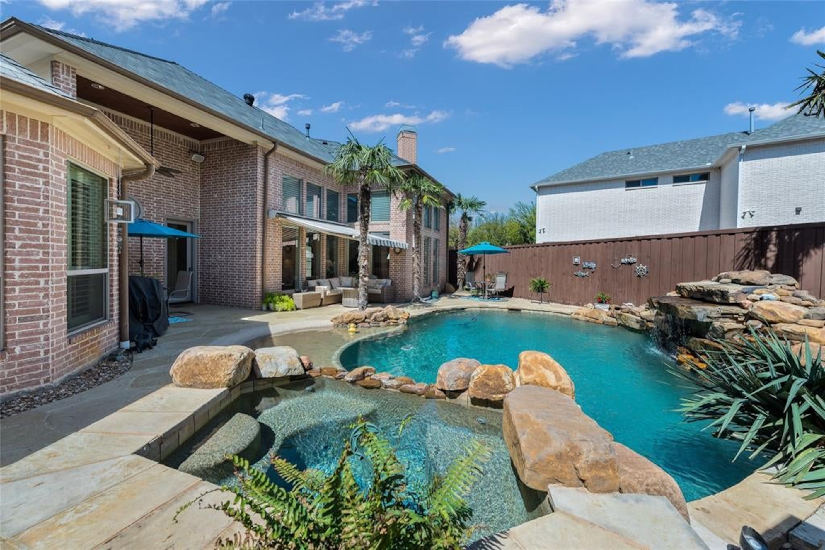 The pool also has a stone fountain, beach entry and spill-over spa.