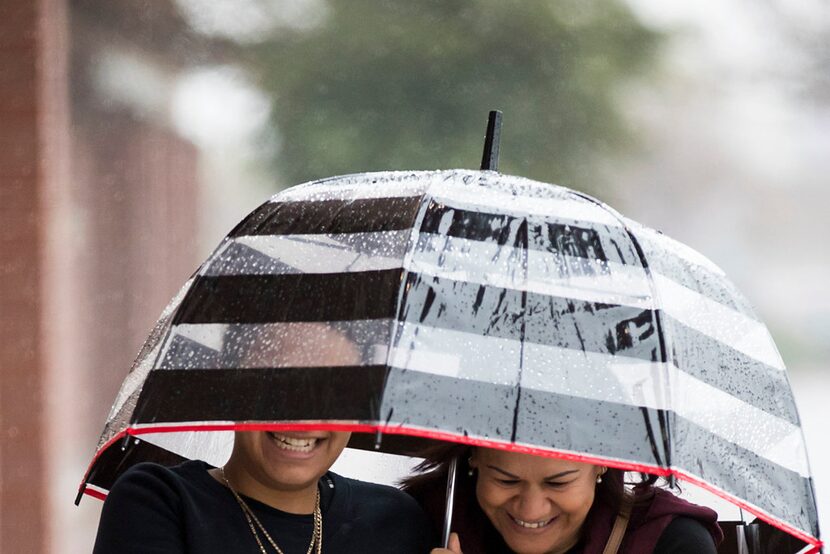 Shoppers bundled against a cold rain in the Wheatland Towne Crossing parking lot on Friday...