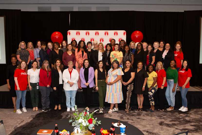 Large group of women stand on a stage at an Empower event for Coca-Cola Southwest Beverages.