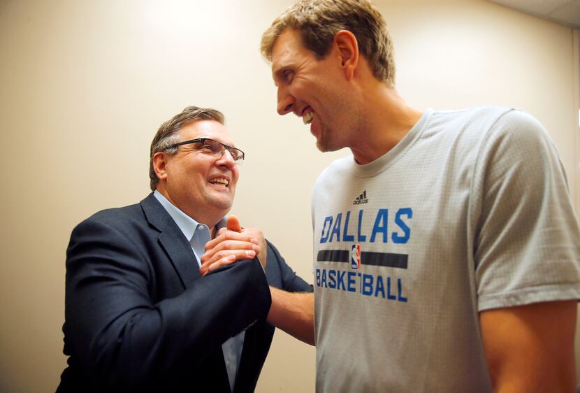 Dallas Mavericks forward Dirk Nowitzki (right) is congratulated by general manager and...