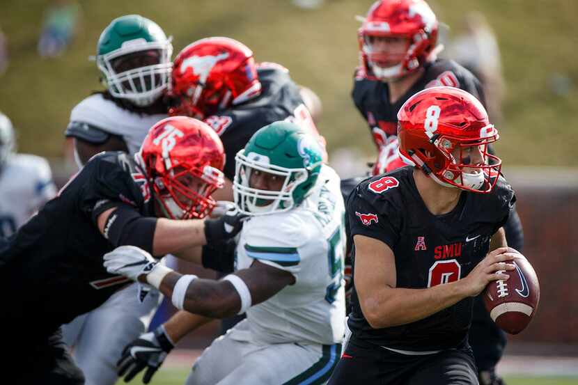 SMU quarterback Ben Hicks (8) scrambles away from the Tulane pass rush as he picks up a...